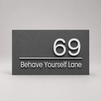 Black sign with white text '69 Behave Yourself Lane' on a gray background