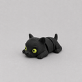 3D printed Teeny Black Panther figure in jet black with yellow-green eyes, lying down