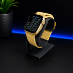 Smartwatch with a yellow braided band on a black stand against a dark background