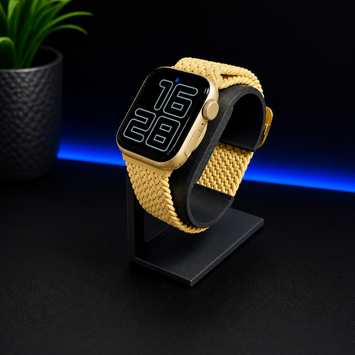 Smartwatch with a yellow braided band on a black stand against a dark background
