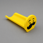 Yellow toy slide with a mustache design on a gray background