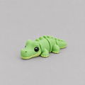 3D printed Teeny Crocodile figure in bright green with ridged back, lying down