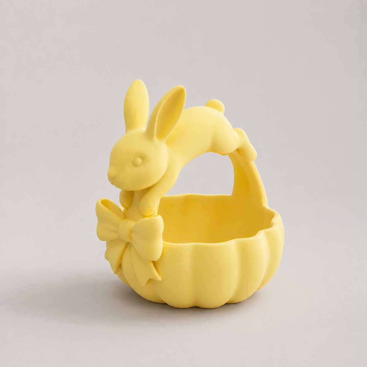 Yellow ceramic basket with rabbit design on a light gray background