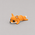 3D printed Teeny Fox figure in vivid orange with white muzzle and tail tip, lying down