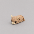 3D printed Teeny Highland Cow figure in warm brown with cream horns, lying down