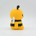 Yellow and black bee-shaped plush toy on a white background