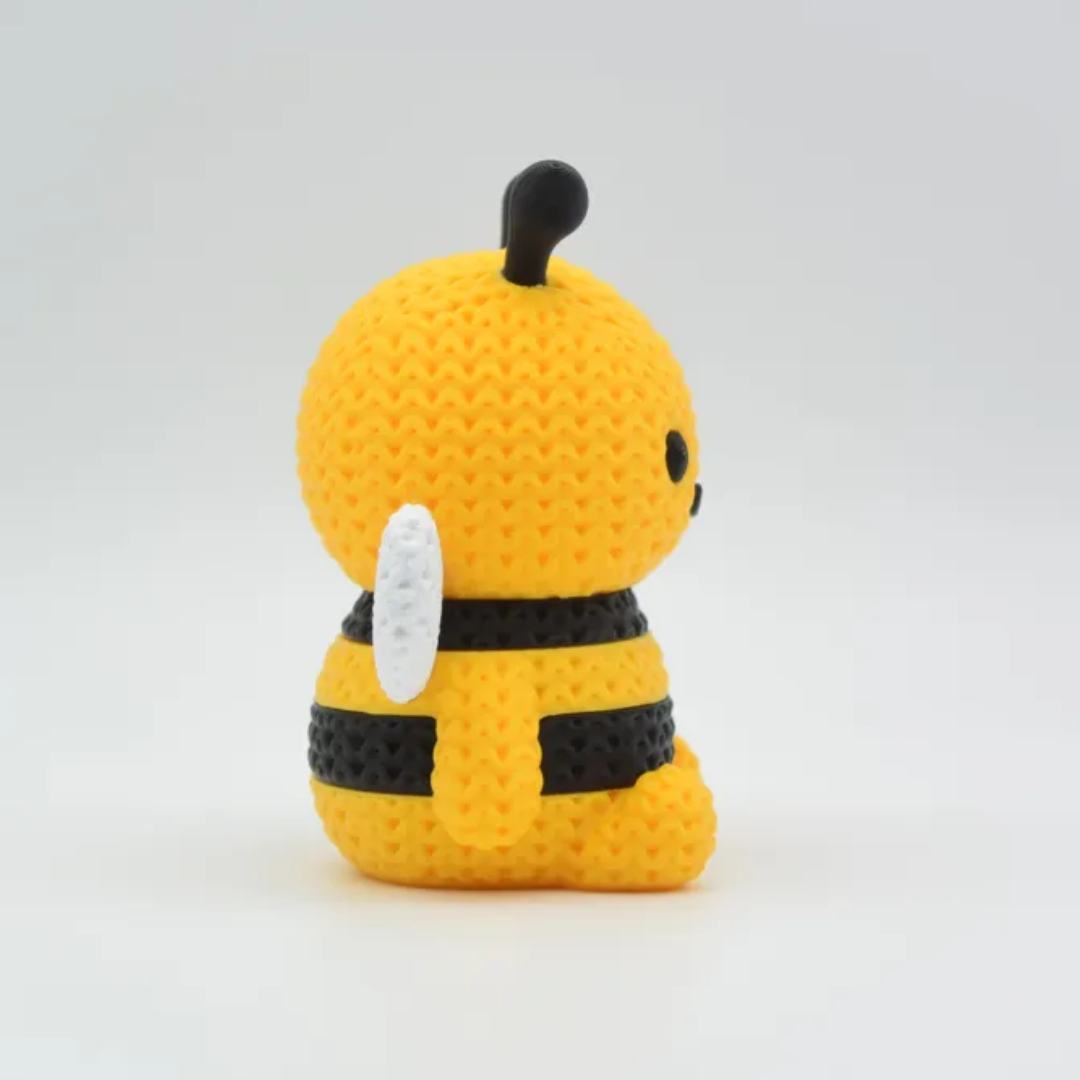 Yellow and black bee-shaped plush toy on a white background