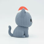 Gray plush cat toy with a red and white hat on a light gray background