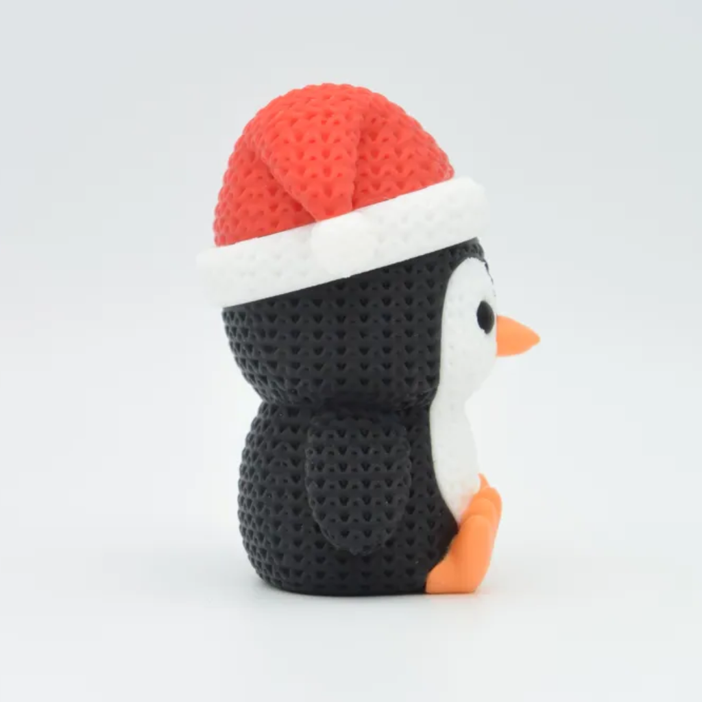 Plush penguin toy with a red and white hat on a light gray background