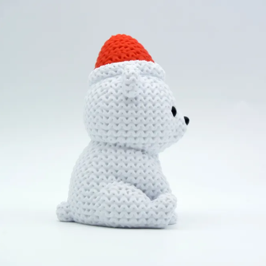 White crocheted bear with a red hat on a light gray background