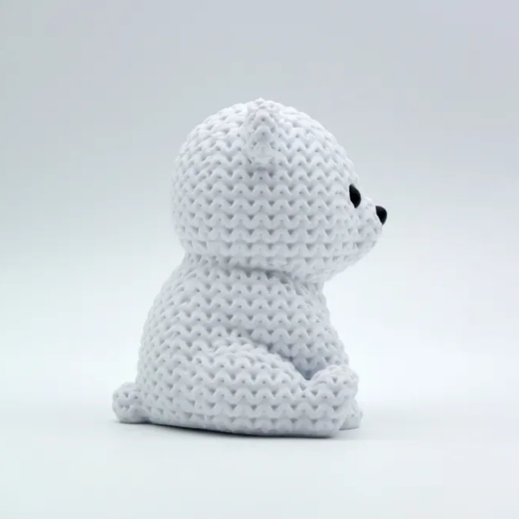 White plush toy with black eyes on a light gray background