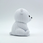 White plush toy with black eyes on a light gray background