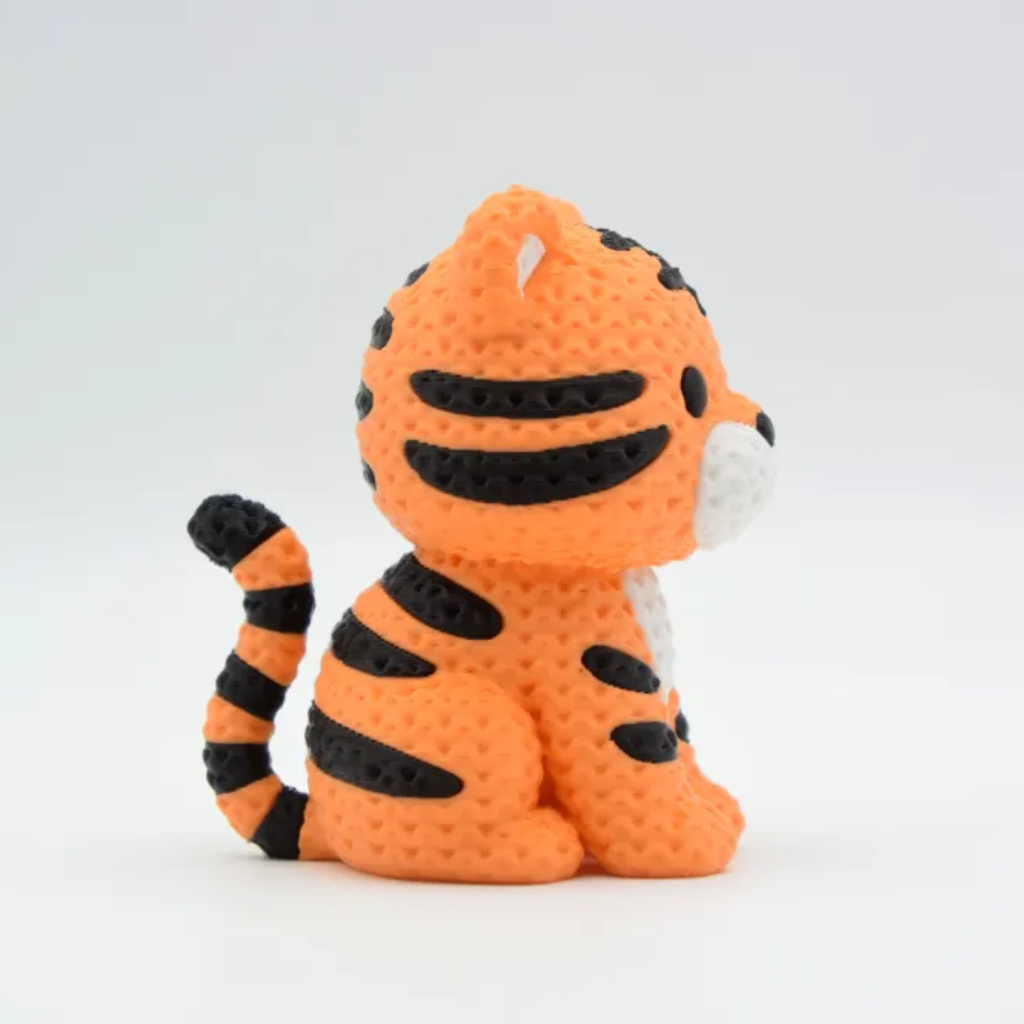 Crocheted tiger toy with black stripes on a white background