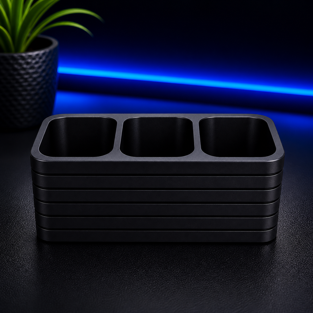 Stack of black trays on a dark surface with blue light in the background