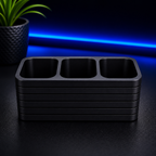 Stack of black trays on a dark surface with blue light in the background