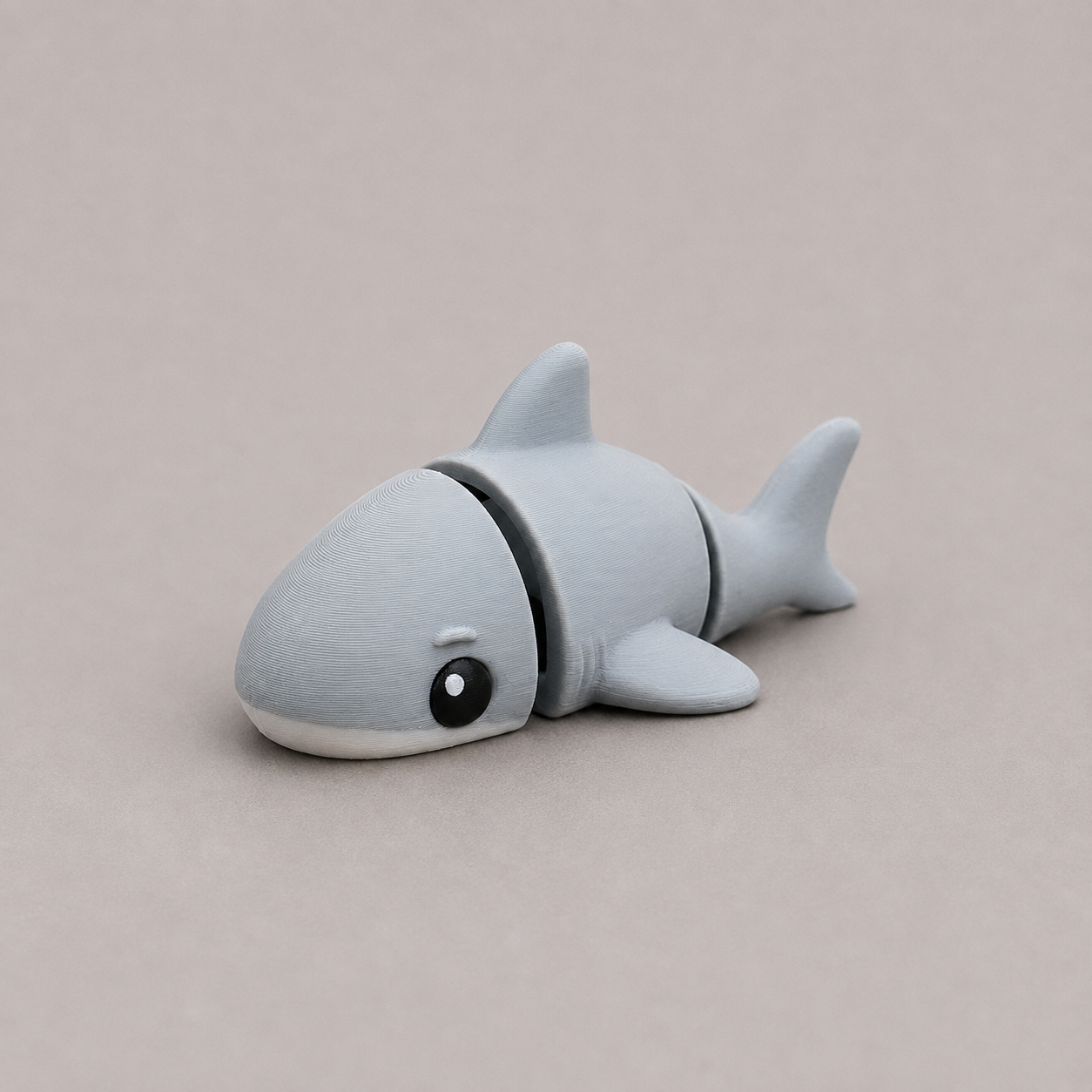 3D printed Teeny Shark figure in blue-grey with white underbelly, lying down