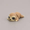 3D printed Teeny Sloth figure in warm sandy beige with cream face, lying down
