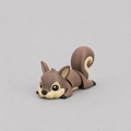 3D printed Teeny Squirrel figure in warm brown with cream face and curled fluffy tail, lying down