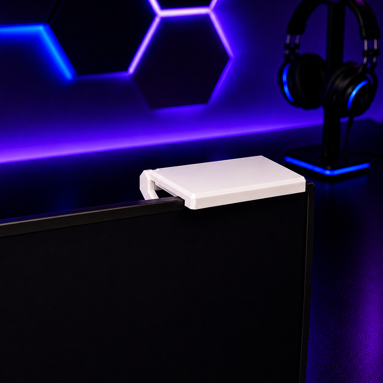 White gaming console on a black desk with purple LED lighting in the background