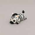 3D printed Teeny Zebra figure in black and white stripes, lying down