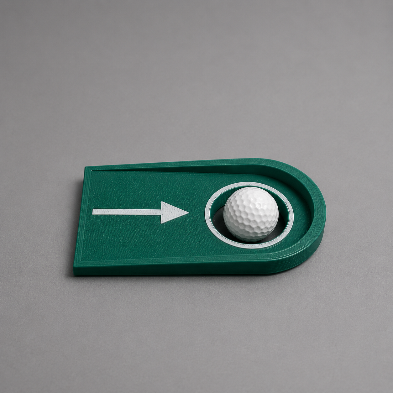 Golf ball in a green plastic golf hole on a gray background